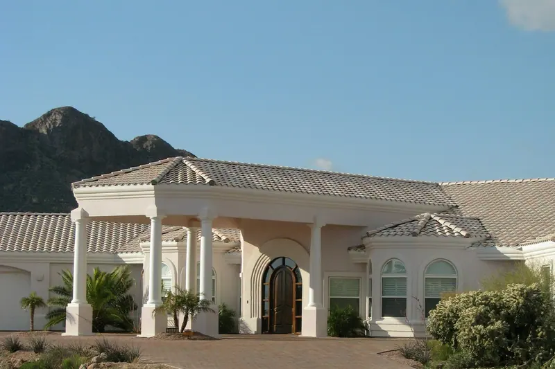 A light stucco house with a clay tile roof and desert landscaping in Gold Canyon, Arizona.